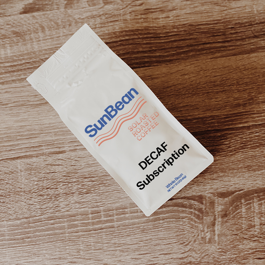 Sun Bean branded coffee bag on wood table. Decaf subscription label.