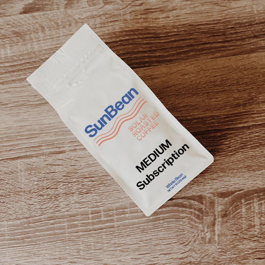 Sun Bean branded coffee bag on wood table. Medium subscription label.